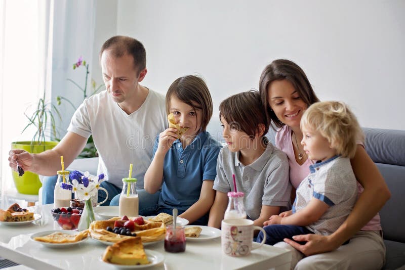 Família feliz comendo panquecas